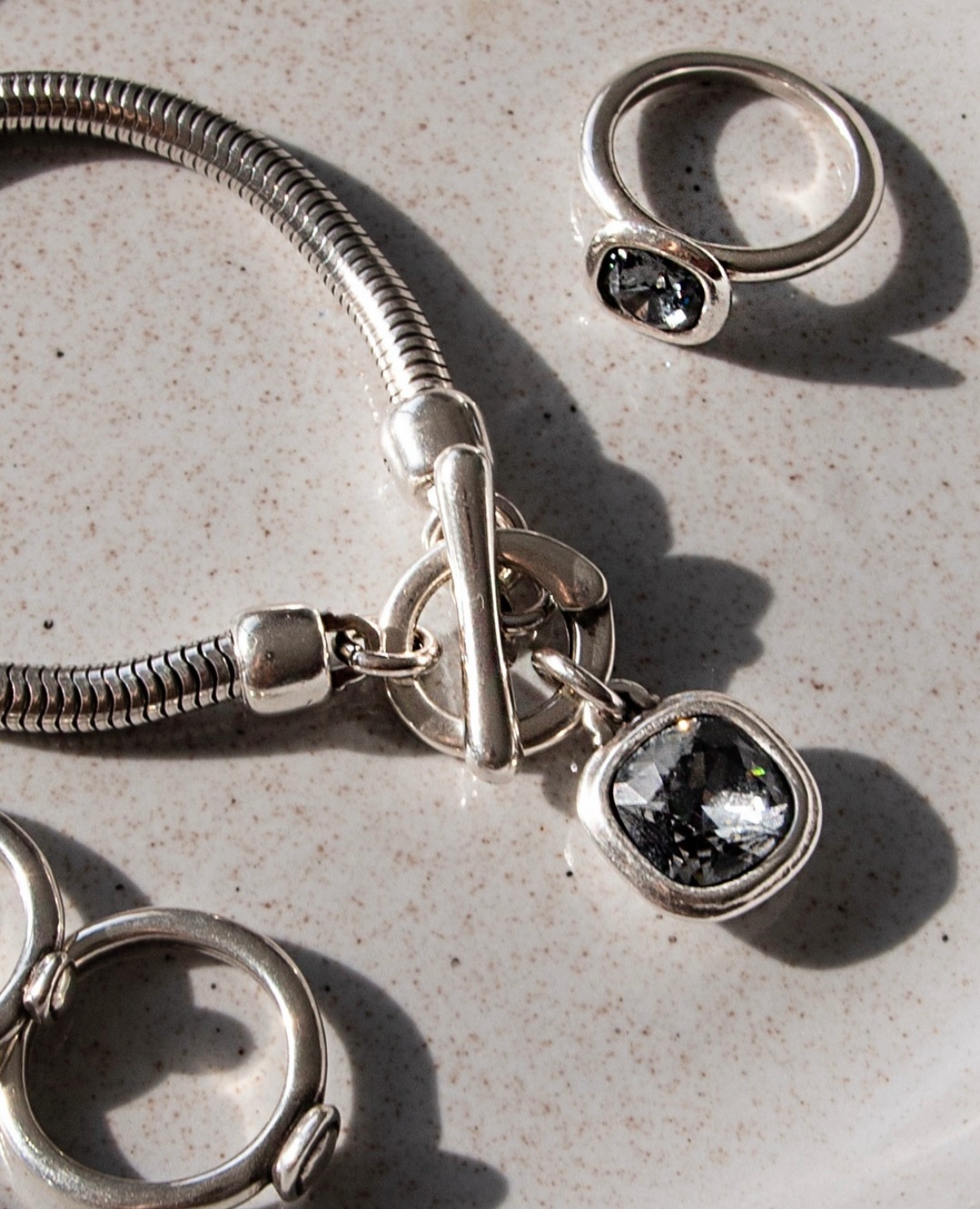 Silver necklace highlighted by a square-shaped white faceted stone