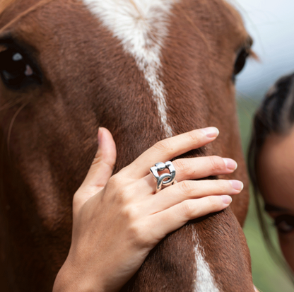 woman wearing silver ring with its distinctive cross-stirrup shape