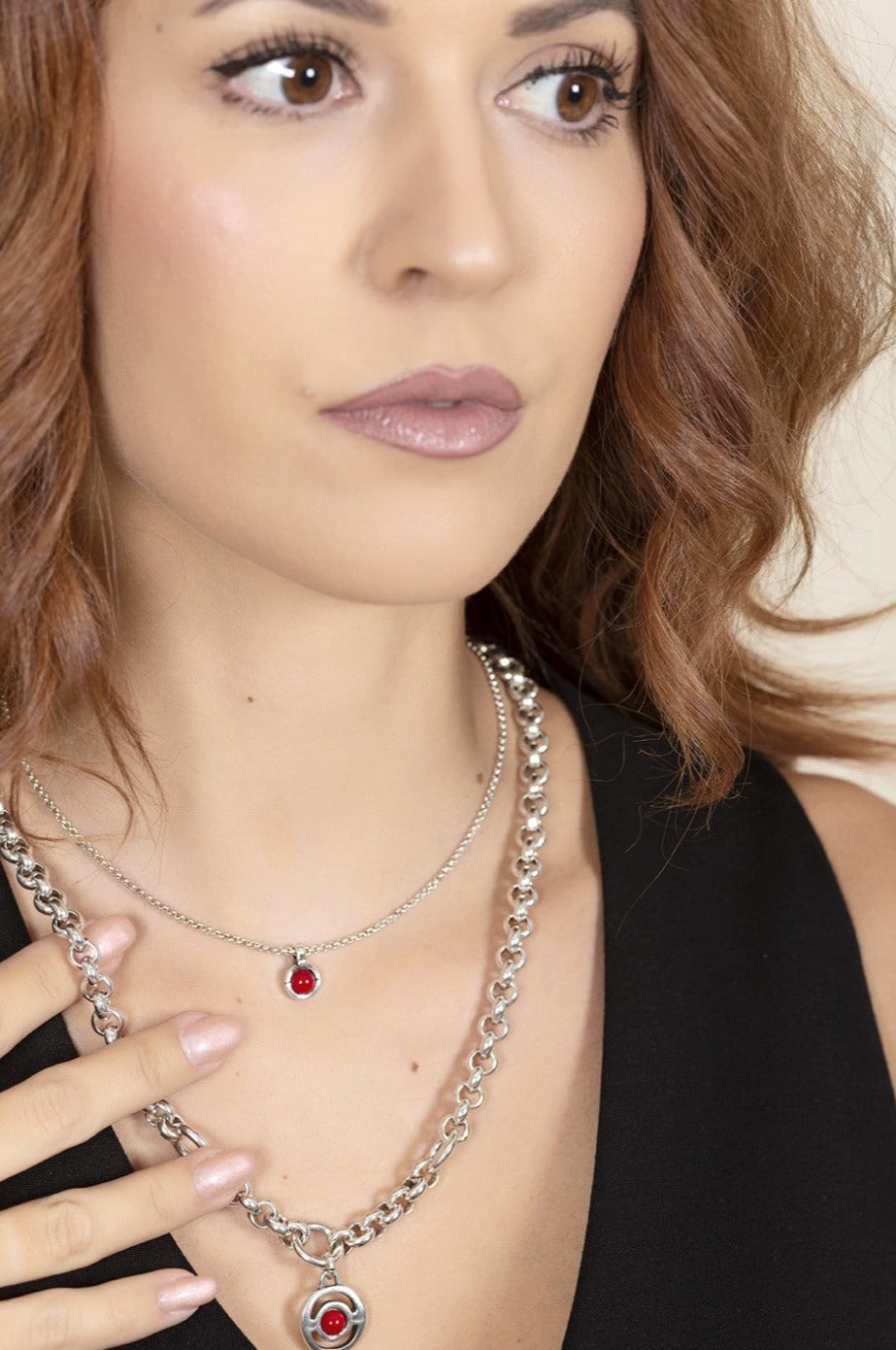 woman wearing silver necklace featuring a pendant adorned with a 15 mm red Murano glass dial at its center