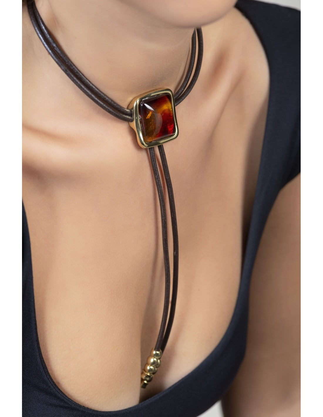 woman wearing Leather necklace with square pendant made of gold and Murano crystals 