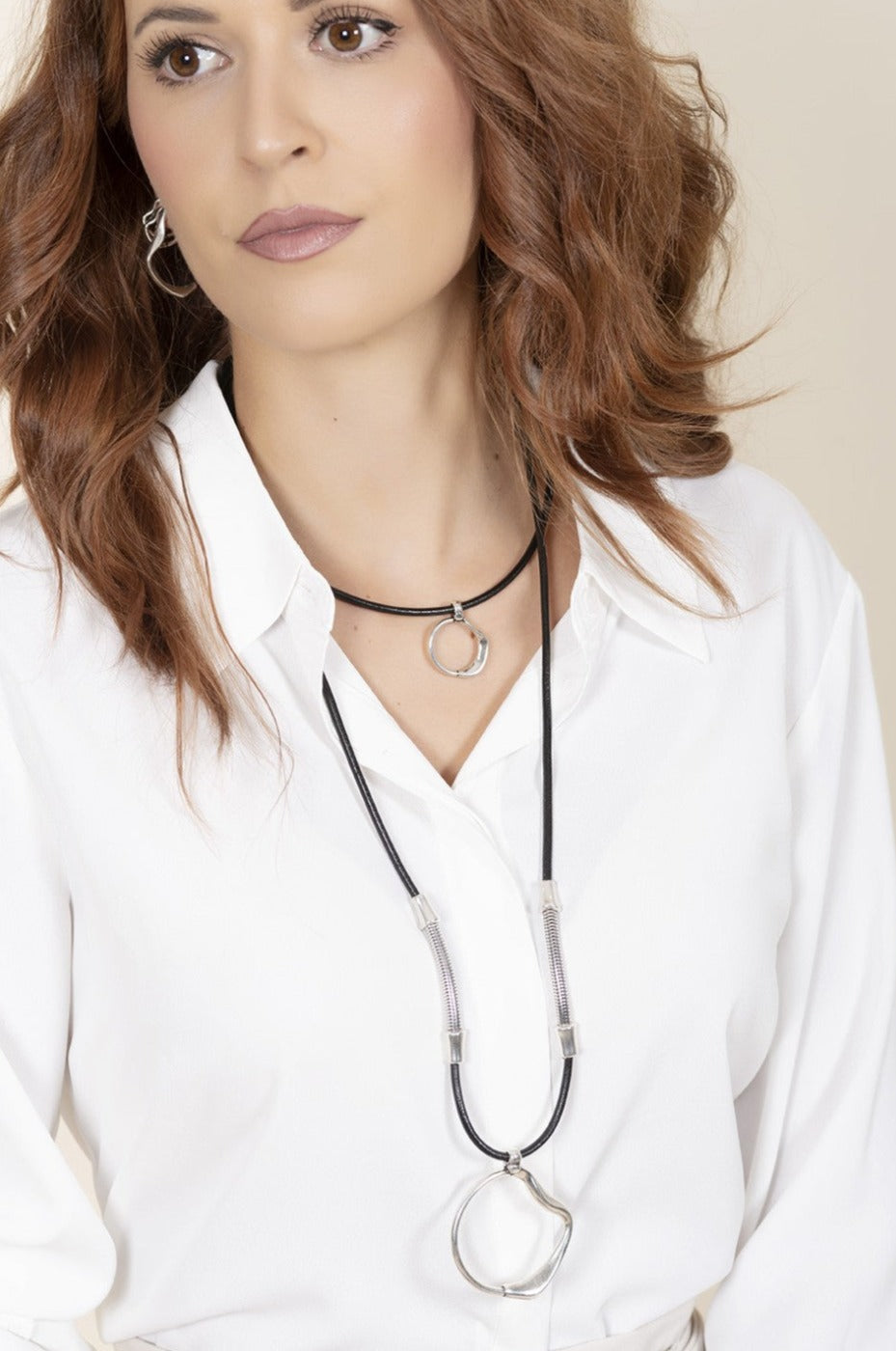 woman wearing leather and silver plated necklace with ciclon logo pendant