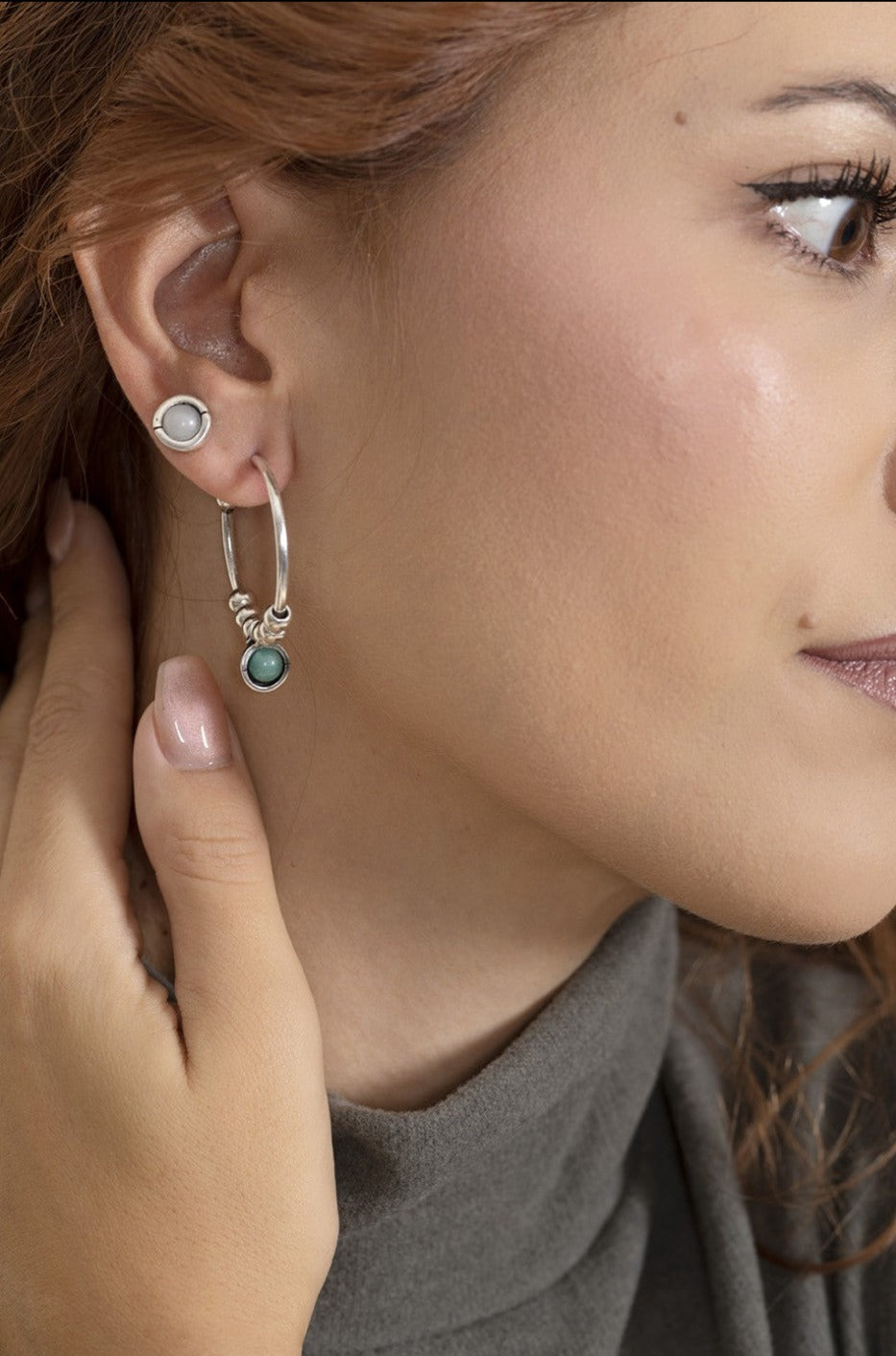 woman wearing silver hoop earrings featuring green Murano glass accents