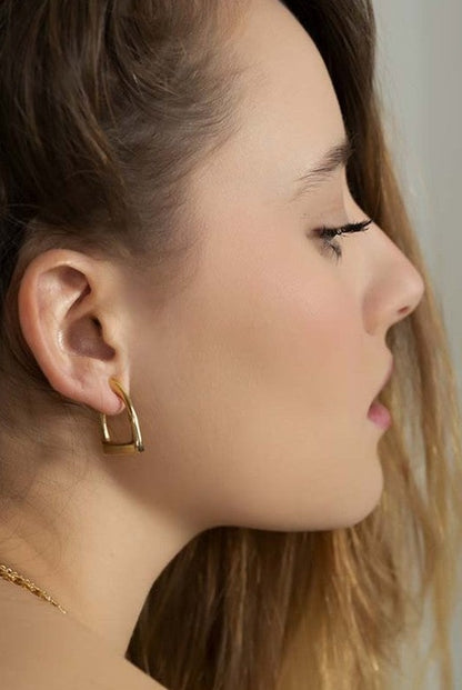 woman wearing stirrup shaped gold earrings