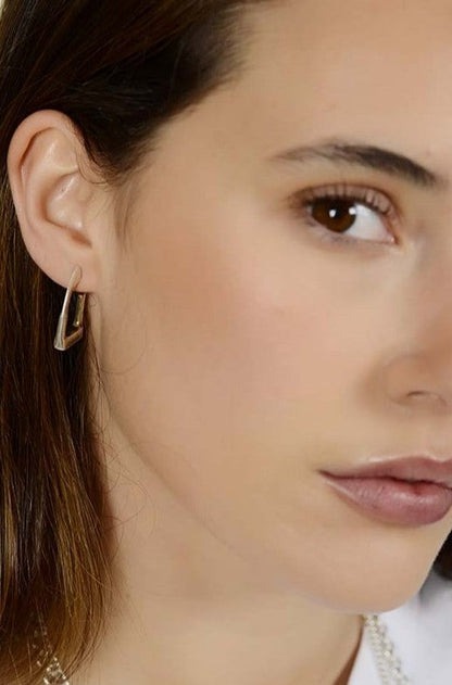 woman wearing stirrup shaped silver earrings