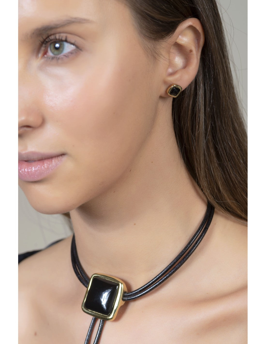 woman wearing gold earrings with black Murano glass detail 