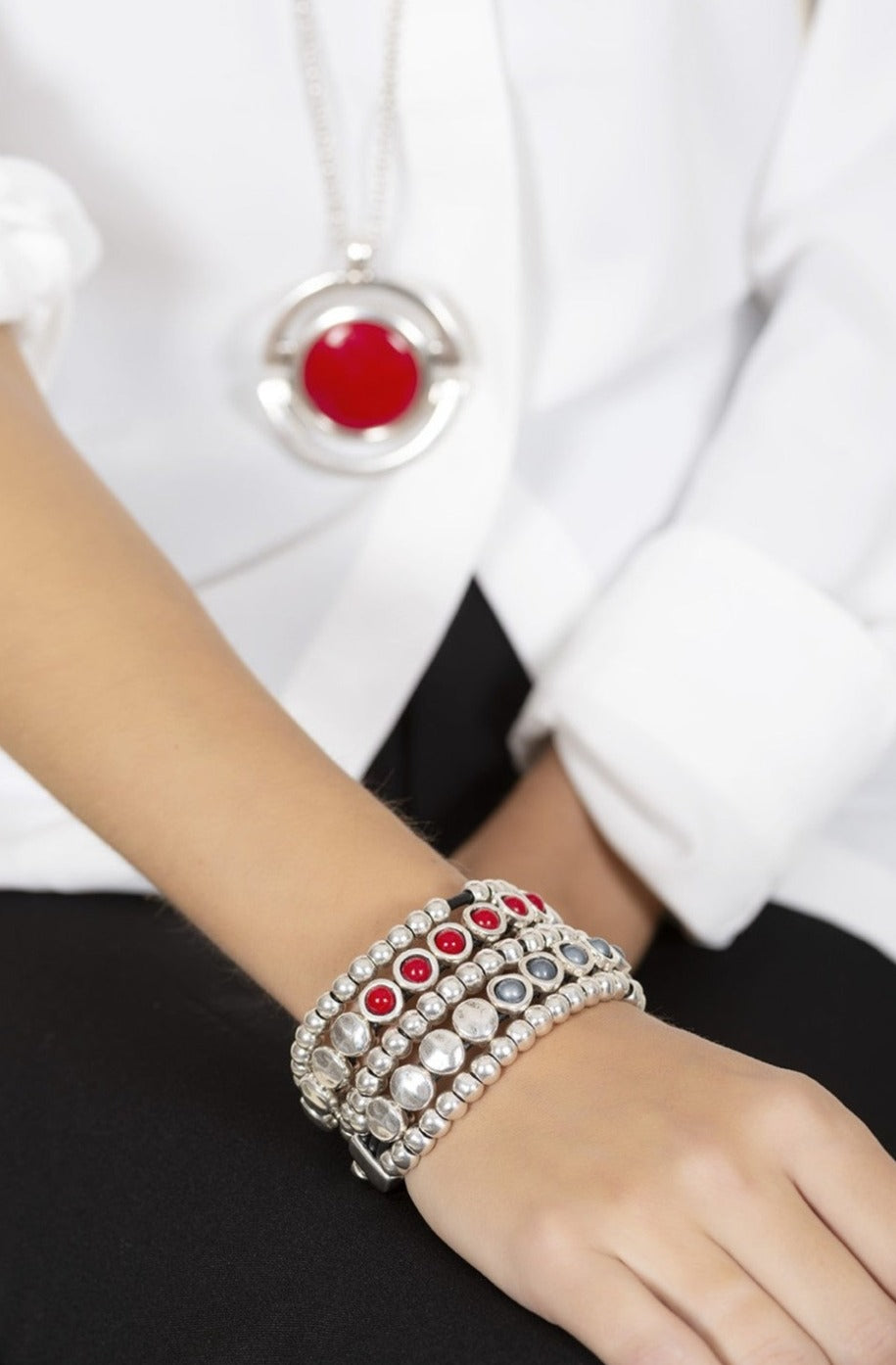 woman wearing three row silver spheres set on leather bracelet, enhanced with a stunning red Murano glass accent