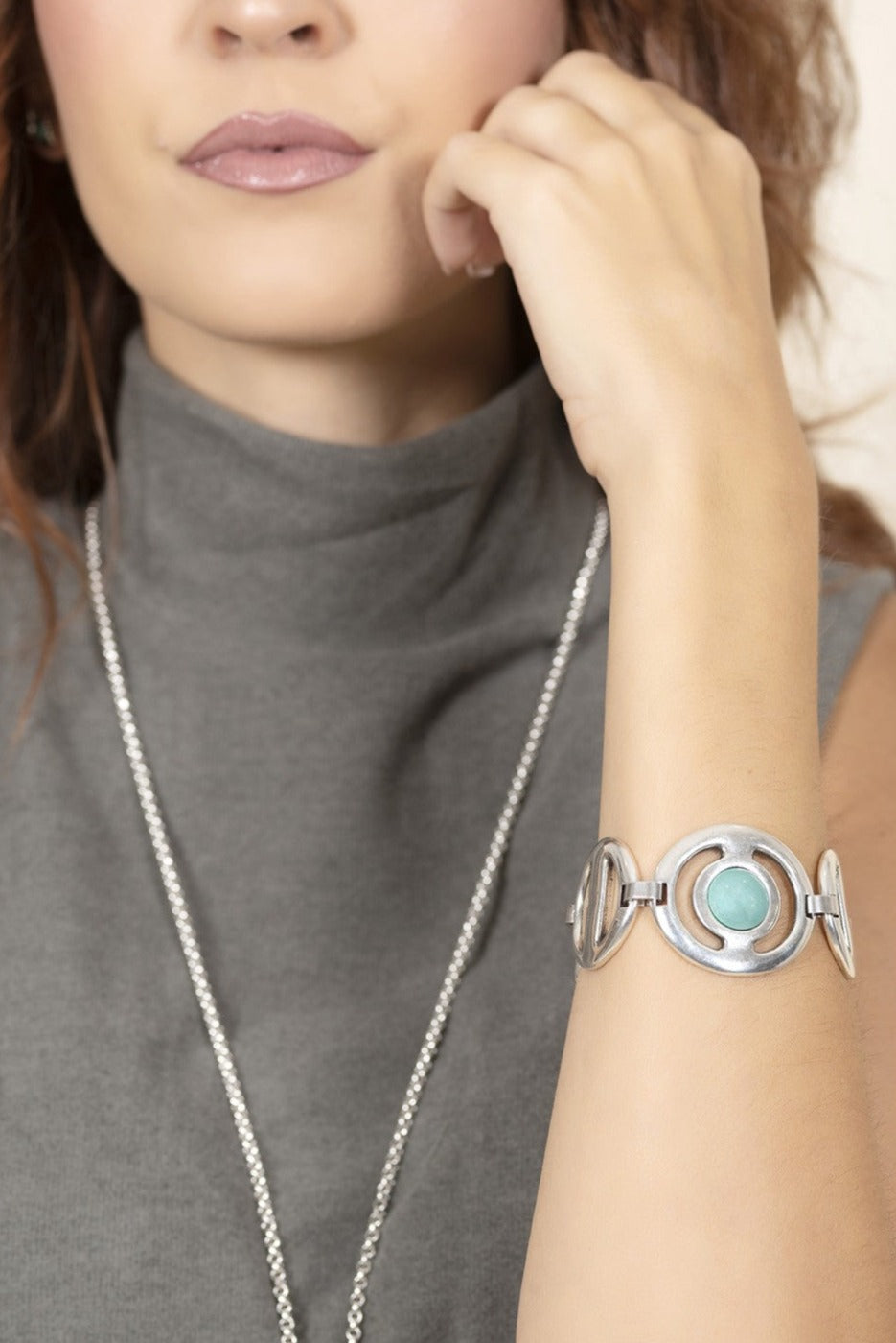 woman wearing silver link bracelet with central motif decorated with turquoise Murano glass sphere