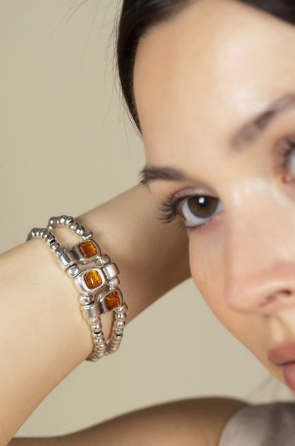 woman wearing silver bracelet with beaded elastic and intricate brown Murano glass details at its center