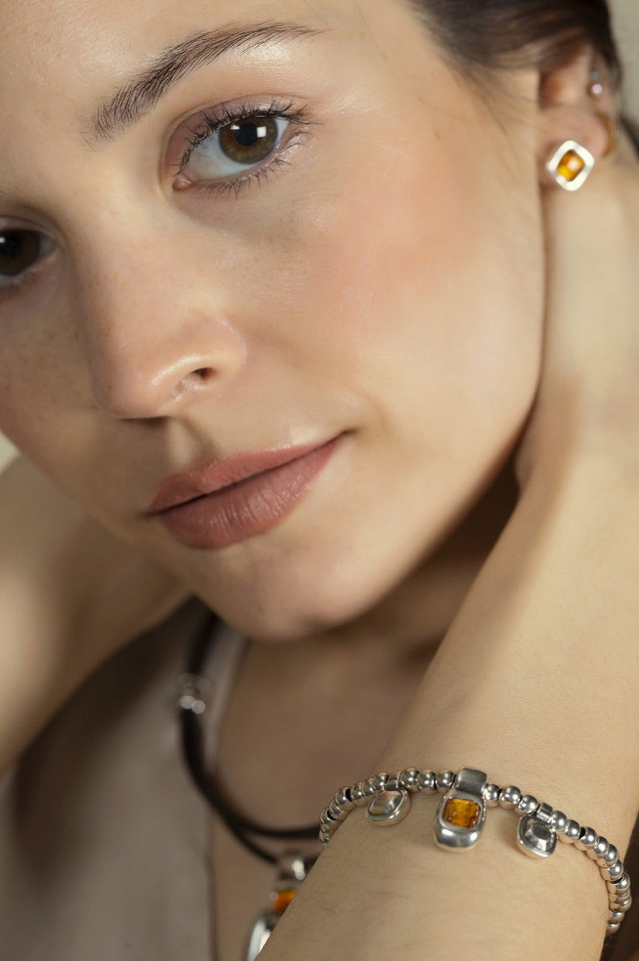 woman wearing silver bracelet with beaded elastic and intricate brown Murano glass details at its center