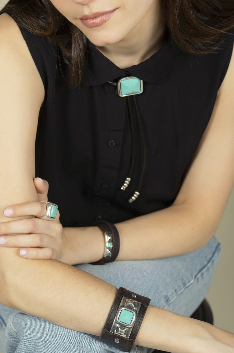 woman wearing leather bracelet with silver center and turquoise Murano glass accents